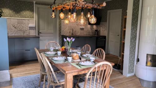 Un comedor con mesa y sillas de madera. en Villa Älgkloster, en Grönskåra
