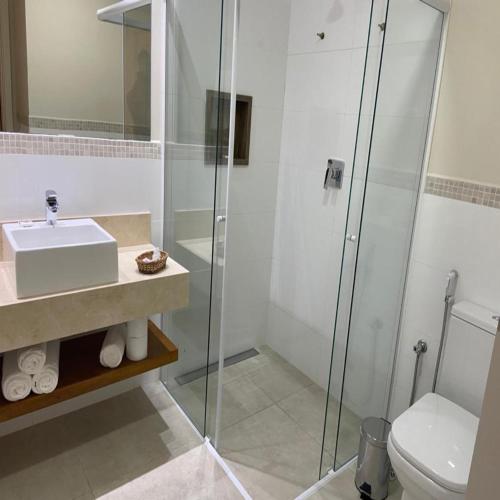 a bathroom with a shower and a sink and a toilet at Hotel Chateau in Campos do Jordão