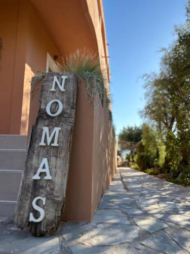 a sign that says newame on the side of a building at Nomas Living in Kalamaki