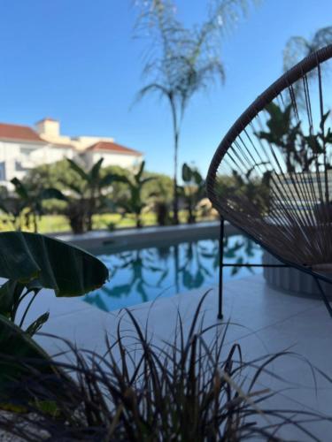 a wicker chair sitting next to a swimming pool at Nomas Living in Kalamaki
