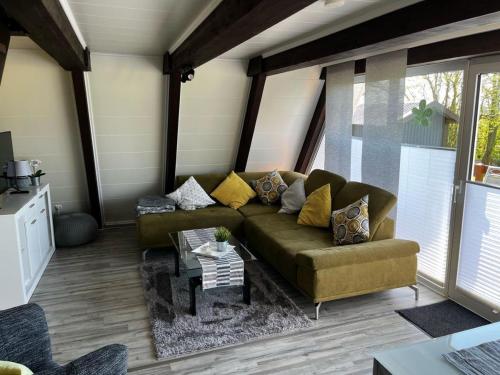 a living room with a couch and a table at Nurdachhaus mit Blick ins Grüne- ruhige Lage nahe Yachthafen Fedderwardersiel in Fedderwardersiel