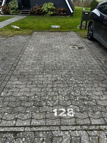 a brick driveway with a car parked on it at Nurdachhaus mit Blick ins Grüne- ruhige Lage nahe Yachthafen Fedderwardersiel in Fedderwardersiel