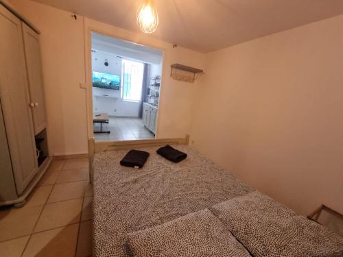 - une chambre dotée d'un lit avec deux chaussures noires dans l'établissement Appartement cosy, à La Ciotat