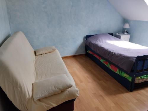 une chambre avec un lit et un canapé dans une pièce dans l'établissement Namaste, à Nans-sous-Sainte-Anne