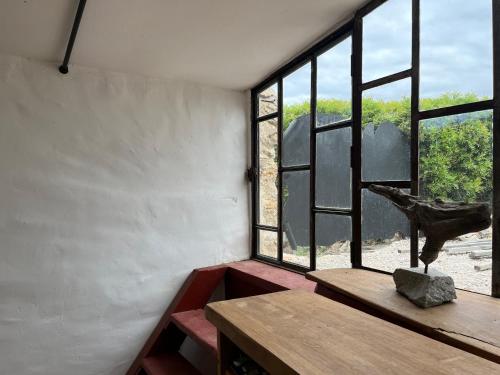une pièce avec une table et une grande fenêtre dans l'établissement Chateau Fitou Presbytery, à Fitou