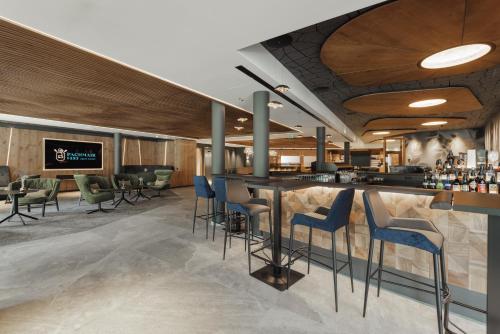 a bar in a restaurant with blue stools at PACHMAIR 1453 apart resort in Uderns