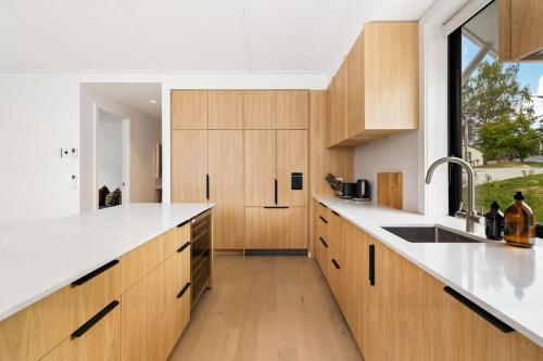 a kitchen with wooden cabinets and a sink and a window at Cottonwood Villa in Arrowtown