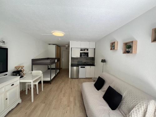 un salon avec un canapé blanc et une cuisine dans l'établissement Studio Climatisé Idéal: Plage et Centre-Ville à Pied, WIFI Gratuit - FR-1-466A-51, à Saint-Raphaël