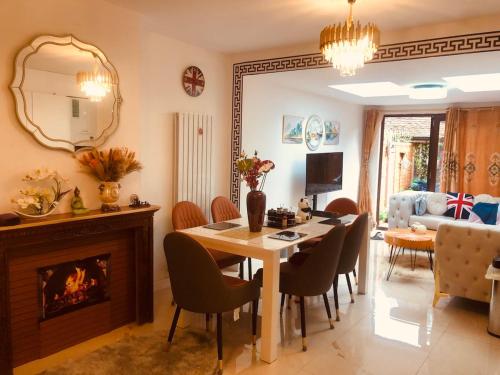 a dining room with a table and chairs and a fireplace at London Central 4 bed House with Garden in London