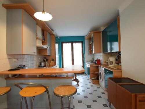 une cuisine avec des armoires en bois et une table et des chaises dans l'établissement Spacieux appartement à Évian, proche centre et lac, pour 5 personnes, animaux acceptés - FR-1-498-7, à Évian-les-Bains
