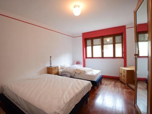 une chambre avec deux lits et un miroir dans l'établissement Spacieux appartement à Évian, proche centre et lac, pour 5 personnes, animaux acceptés - FR-1-498-7, à Évian-les-Bains