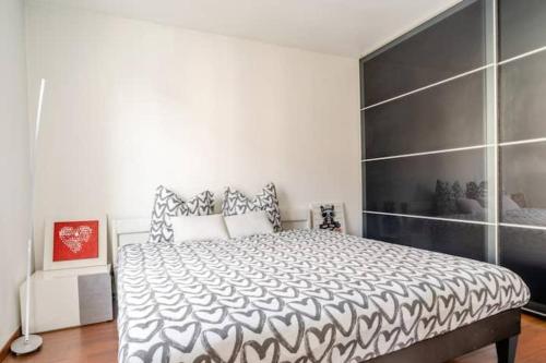 a bedroom with a bed with a black and white comforter at Location Professionnelle - Maison 2 à 4 personnes proche Disney-Astérix-CDG in Villeparisis