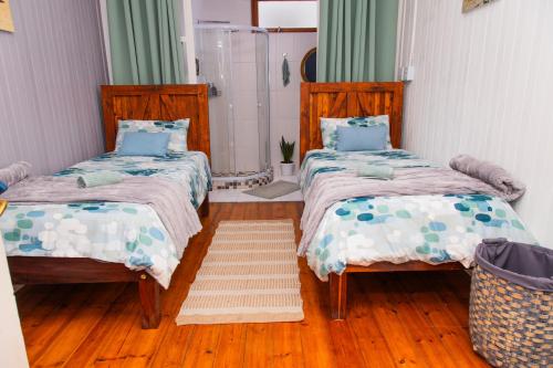 two beds in a room with wooden floors at Wildhorses B&B and Self Catering in Lüderitz