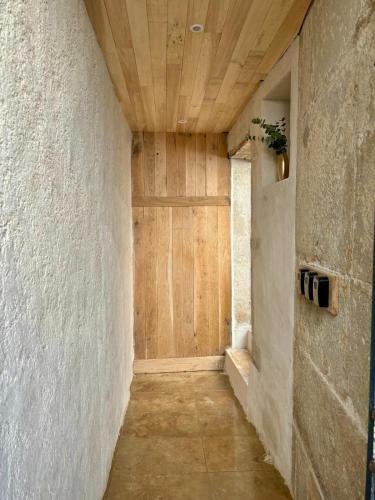 un couloir avec une porte en bois dans un bâtiment dans l'établissement Au cœur de la Citadelle, à Semur-en-Auxois