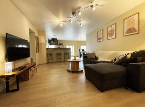 a living room with a couch and a table at Cocon de la belle de Vosges 3 chambres in Remiremont