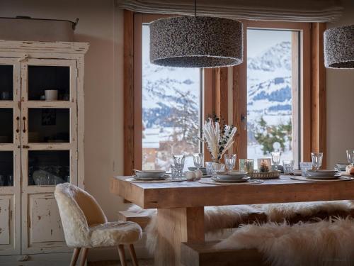 Un comedor con una mesa y un gran ventanal. en Chalet Marmot'Inn - OVO Network, en Notre-Dame-de-Bellecombe