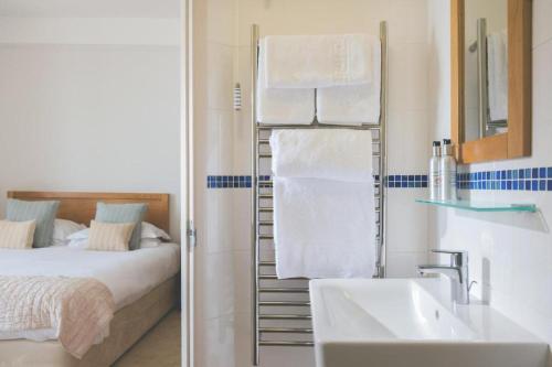 a bathroom with a bed and a towel rack with a sink at The Ship Inn in Mousehole