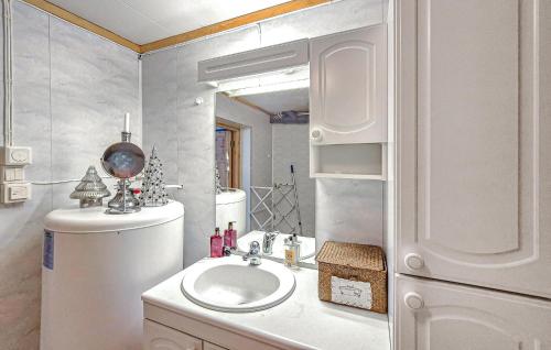 a white bathroom with a sink and a mirror at Nice Home In Manger With House Sea View in Manger