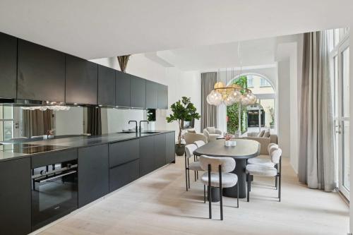 a kitchen with black cabinets and a table with chairs at Luxury Stay by Freetown & Canals in Copenhagen