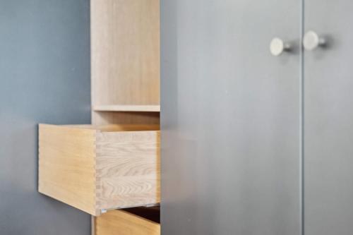a small kitchen with wooden cabinets and ajar doors at Luxury Stay by Freetown & Canals in Copenhagen