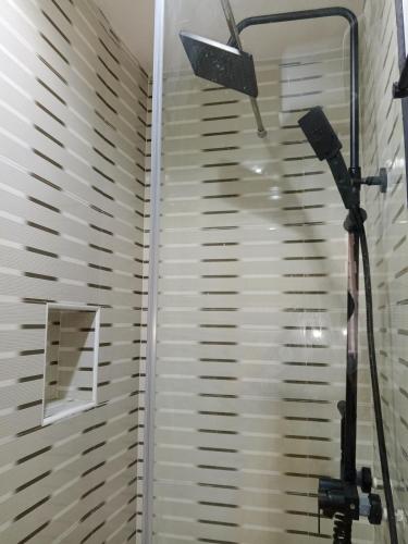 a shower with a light and a window with blinds at Grace court apartments in Alimosho