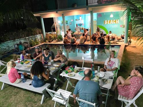 un gruppo di persone seduti intorno alla piscina di Vila da Sereia hostel e pousada a Icaraí