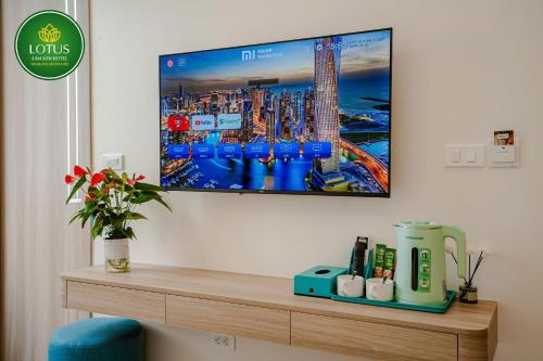 a room with a tv on a wall with a table at Lotus Sầm Sơn Hotel in Sầm Sơn