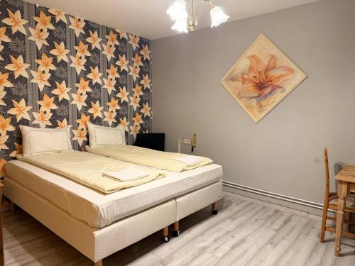 a bedroom with two beds and a floral wallpaper at Deutsches Haus in Malchow