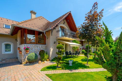 a house with a garden and a patio at Helka Apartmanház in Balatonlelle