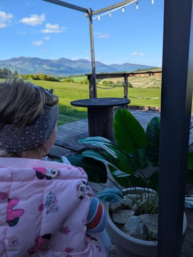 a little girl sitting next to a potted plant at Sidehill - zážitkové ubytovanie v prírode in Martin