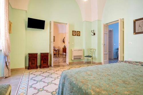 a bedroom with a bed and a room with a television at Donna Cesarina - Maison de Charme in Maruggio