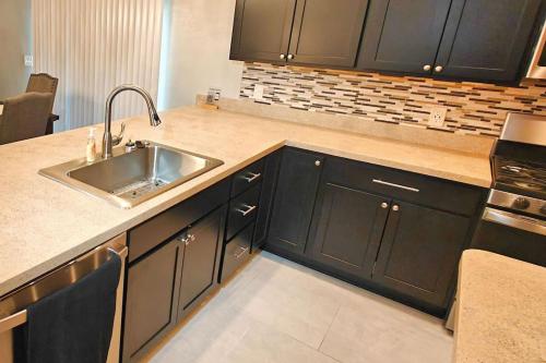 a kitchen with black cabinets and a sink at Serenity In The Villages in The Villages