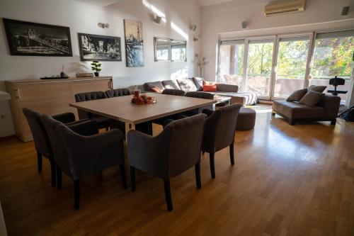 a living room with a table and chairs at Penthouse Secret Rose with pool, jacuzzi, sauna, private garage, entry with pin 0-24h in Slavonski Brod