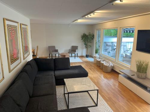 a living room with a black couch and a table at Holiday Home 36A BÅSTAD in Båstad