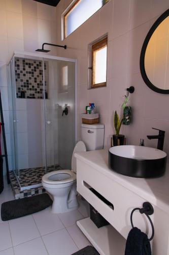 a bathroom with a toilet and a sink and a shower at Wildhorses B&B and Self Catering in Lüderitz