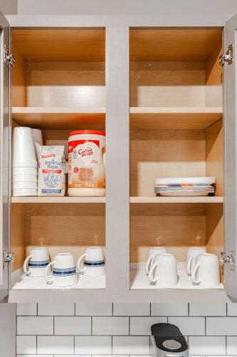 a cupboard filled with dishes and other kitchen items at Spacious Whitestown Getaway in Whitestown