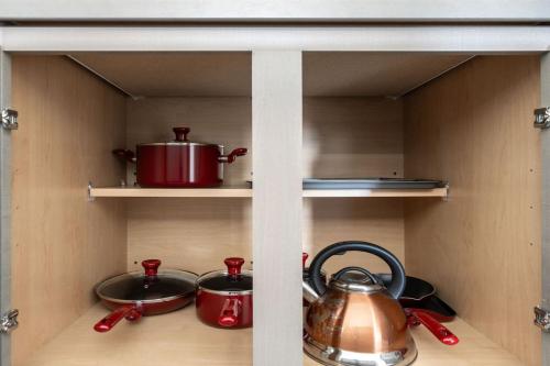 a cabinet with pots and pans and a tea kettle at Spacious Whitestown Getaway in Whitestown