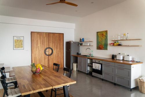 a kitchen with a wooden table and a dining room at House of Rising Sun in Thong Nai Pan Noi