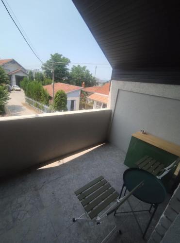 a room with a chair and a table on a balcony at Top 4 Sobe, Rooms - Near the airport in Niš