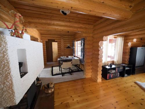 ein Wohnzimmer mit Kamin in einer Blockhütte in der Unterkunft Villa Pihlajanmarja is a Stunning Log Villa on a Waterfront Estate in Långstrand