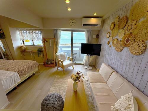 a living room with a couch and a tv at Ocean Front! New Built Apartment! SOU Resort YAKA in Kin