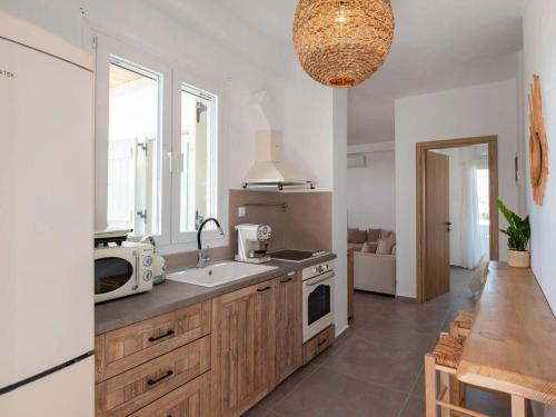 a kitchen with a sink and a microwave at Pounta Condo 1 - Shared pool in Pounda