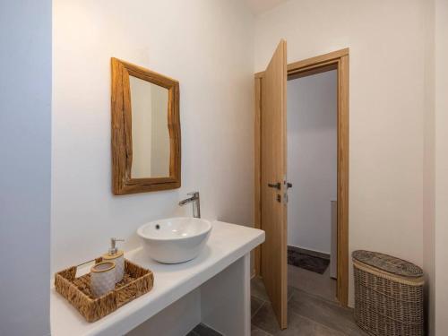 a bathroom with a white sink and a mirror at Pounta Condo 1 - Shared pool in Pounda