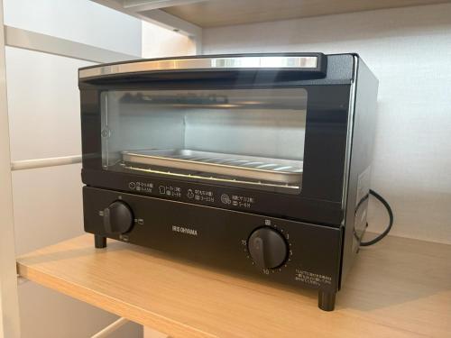 a toaster oven sitting on top of a table at Ocean Front! New Built Apartment! SOU Resort YAKA in Kin