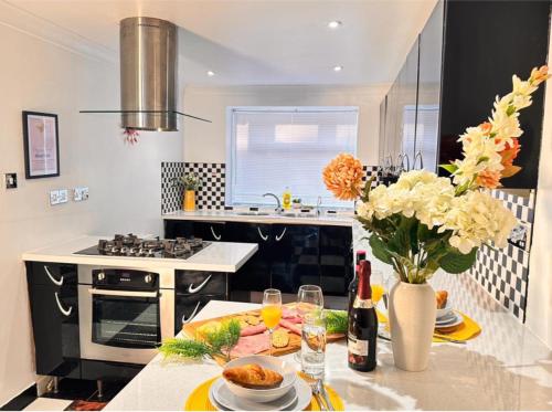 a kitchen with a table with flowers and wine bottles at Charming 3-bedroom House with Garden in Portsmouth, Close Parking, Train Station & Gunwharf in Portsmouth