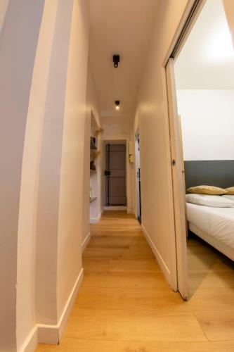 un couloir menant à une chambre avec un lit dans l'établissement Agréable appartement dans le 13ème arrondissement, à Paris