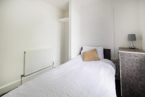 a small bedroom with a white bed and a lamp at OYO A Better Night Hotel - Manchester Salford in Manchester