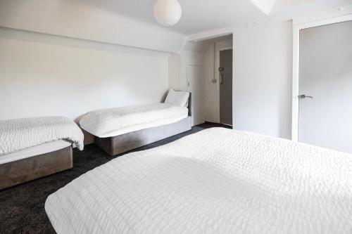 two beds in a room with white walls at OYO A Better Night Hotel - Manchester Salford in Manchester