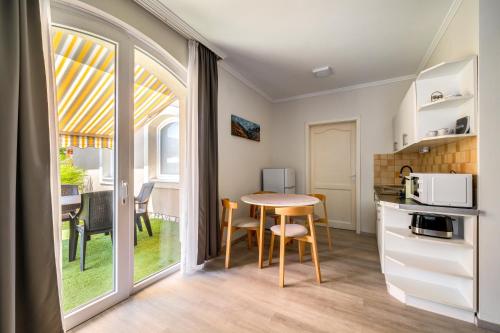 a kitchen with a table and a dining room at Helka Apartmanház in Balatonlelle
