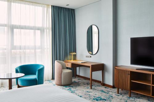 a hotel room with a bed and a desk and a television at The g Hotel & Spa in Galway